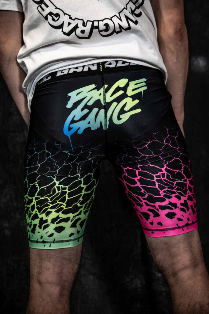 Lycrowe spodnie RaceGang z dynamicznym wzorem pękającej ziemi, elastyczną gumką w pasie oraz detalami „RaceGang” i „It’s Sick”.