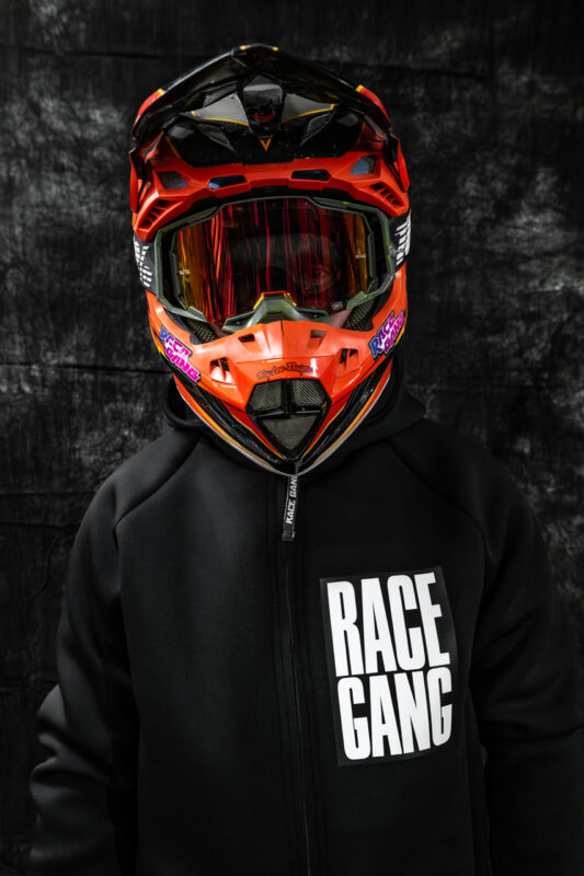 Neoprenowa kurtka RaceGang z kapturem, logo na piersi i plecach, napisem na rękawie, idealna do sportów ekstremalnych i aktywności na świeżym powietrzu.